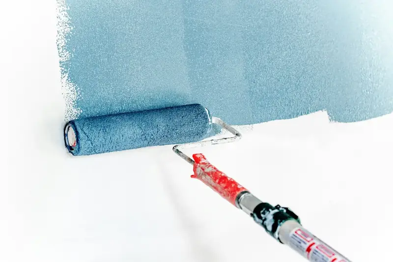 Rouleau appliquant de la peinture bleue sur un mur